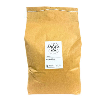 Kraft paper bag of organic millet flour with a label on a white background