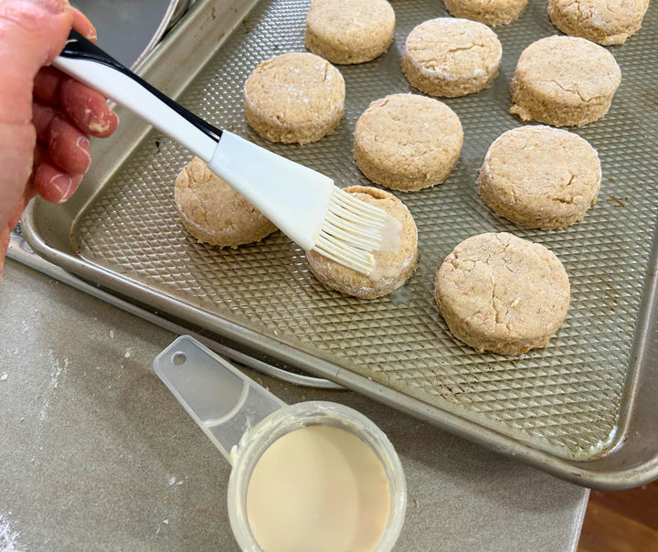Brushing homemade scones with milk. These scones were made from freshly milled soft organic wheat grain grain. Purple straw is a soft wheat grain that is perfect for cakes, biscuits, cookies and scones