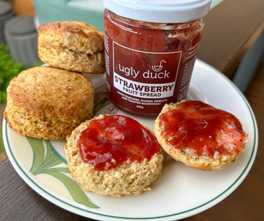 Freshly baked homemade scones on a plate with fresh strawberry jam made from seconds strawberries. The scones were made from freshly milled organic soft wheat grain. The soft wheat grain was a variety called purple straw. Purple straw is a soft wheat grain that is perfect for cakes, biscuits, cookies and scones